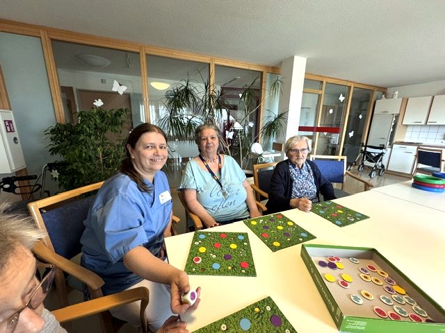 Betreuungskräfte und Bewohnerinnen beim gemeinsamen Brettspiel