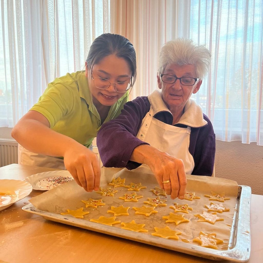 Bewohnerin und Betreuungskraft backen gemeinsam Plätzchen in der Wohngruppe Weimarstraße